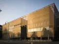 Moderne Architektur der Kunsthalle Mannheim im goldenen Abendlicht. Vor dem Gebäude laden Tische und Stühle zum Verweilen ein.