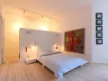 Modernes Schlafzimmer mit Bett, Kunstwerk und Einbauschränken. Tolle Renovierungsideen für minimalistische Räume.