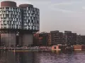 Moderne Architektur und schwimmende Holzhäuser am Wasser in Nordhavn Kopenhagen. Menschen genießen die Abendsonne.