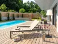 Traumhafte gartengestaltung mit pool und terrasse. Zwei Liegen laden zum Entspannen ein, während der Pool erfrischt.