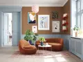 Ein Wohnzimmer mit braunen Wänden, hellblauen Türen und Akzenten. Welche Farbe passt zu Beige und Braun? Hier: Orange Möbel und ein rosa Teppich.