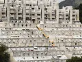 Massive Wohnanlage im Stil der brutalismus architektur, mit terrassierten Ebenen und vielen runden Fenstern.