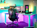 Kleine Gaming-Zimmer-Ideen: Ein Spieler genießt bunte Beleuchtung und zwei Monitore.