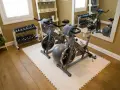 Zwei Heimtrainer, Hanteln und ein Gymnastikball – tolle home gym ideen für dein Workout zu Hause.