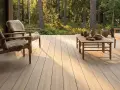 Holzdeck mit bequemen Sesseln und Tisch, umgeben von Wald. Ein **garten skandinavisch gestalten** – minimalistisch und naturverbunden.
