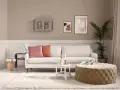 Gemütliches Wohnzimmer mit cremefarbener Couch, passenden Kissen und einem Hocker. Die ecru farbe kombinieren sich harmonisch mit den Wandfarben und Deko-Elementen.