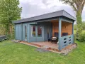 Ein blaugrünes Gartenhaus mit Veranda und Sitzgelegenheiten. Tolle Gartenhaus Farben Ideen für Ihr grünes Paradies.