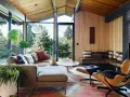 Gemütliches Wohnzimmer im **mid century modern** Stil mit großen Fenstern, Holzdecken und einer gemütlichen Sitzecke.