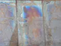 Verwittertes Metall mit schillernden Farben, die die Bedeutung von Patina zeigen. Rostige und blaue Muster erzählen eine Geschichte der Zeit.