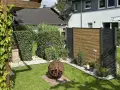 Schöner Garten mit Hecken und Holzzaun als Sichtschutz. Eine Feuerkugel und Pflanzen schaffen Gemütlichkeit. Tolle Ideen für Sichtschutz im Garten.