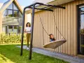 Tolle spielecke garten ideen kinder: Ein Mädchen schaukelt fröhlich, während eine Frau zusieht.