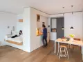 Clevere raumaufteilung ideen: Ein Bettbereich ist vom Wohnbereich durch eine weiße Wand getrennt. Eine Küche und ein Essbereich sind integriert.