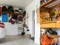 Praktische garage einrichten ideen: Werkzeugwand, Regale mit Taschen und ein Kompressor schaffen Ordnung.