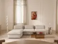 Ein Wohnzimmer in sanften Tönen. Die Farbe Ecru dominiert bei Sofa, Teppich und Vorhängen und schafft eine warme, einladende Atmosphäre.