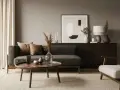 Gemütliches Wohnzimmer, in dem sich braun und grau kombinieren. Ein dunkles Sofa mit Kissen, ein runder Holztisch und ein Teppich schaffen eine warme Atmosphäre.