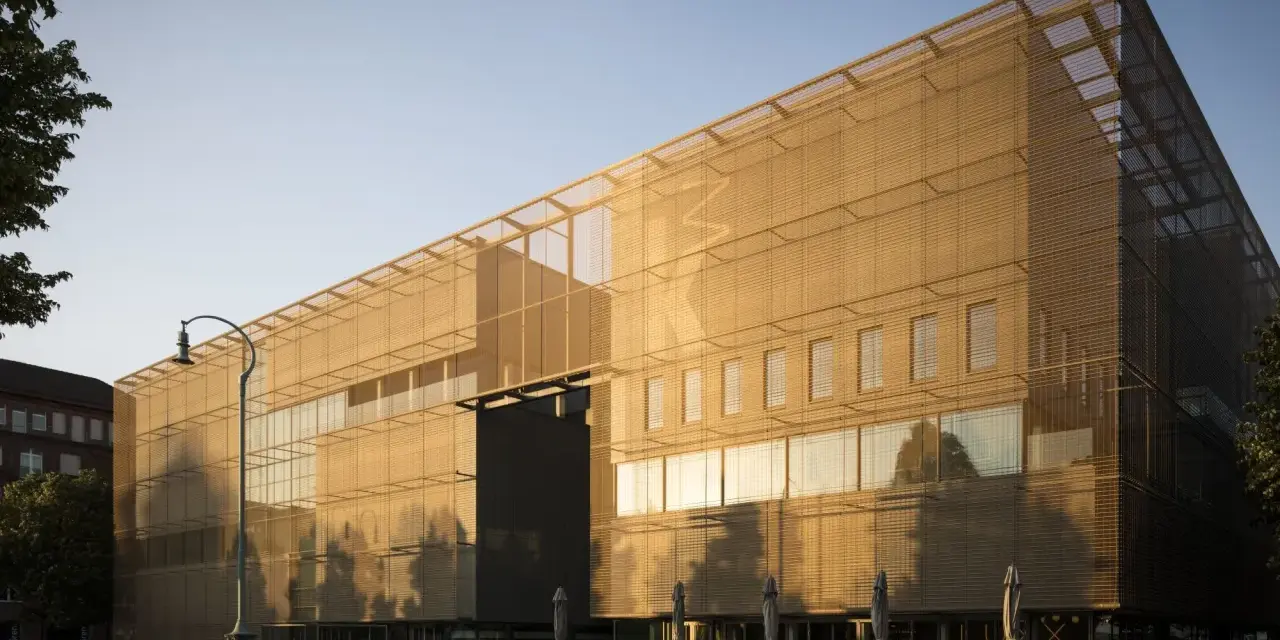 Moderne Architektur der Kunsthalle Mannheim im goldenen Abendlicht. Vor dem Gebäude laden Tische und Stühle zum Verweilen ein.