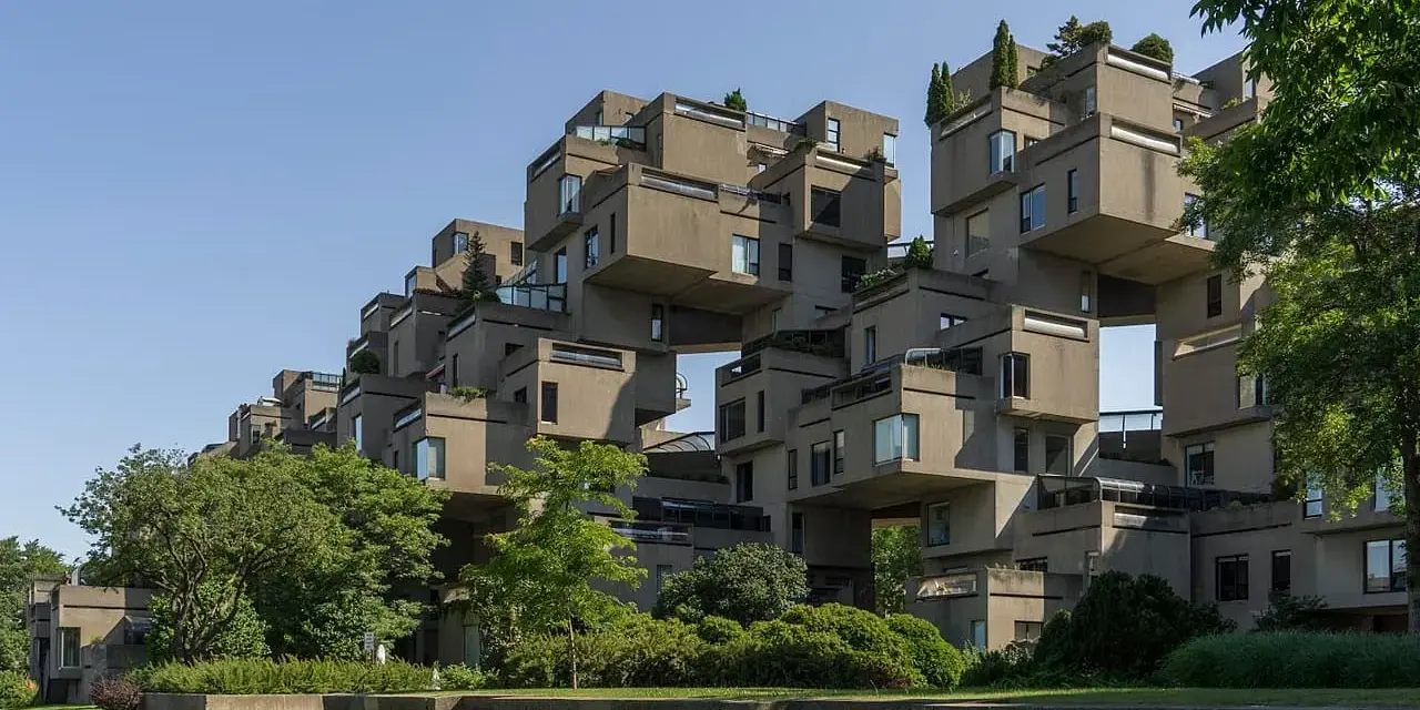 Ein beeindruckendes Beispiel brutalistischer Architektur: Betonblöcke stapeln sich zu einer futuristischen Wohnanlage, umgeben von Grün.