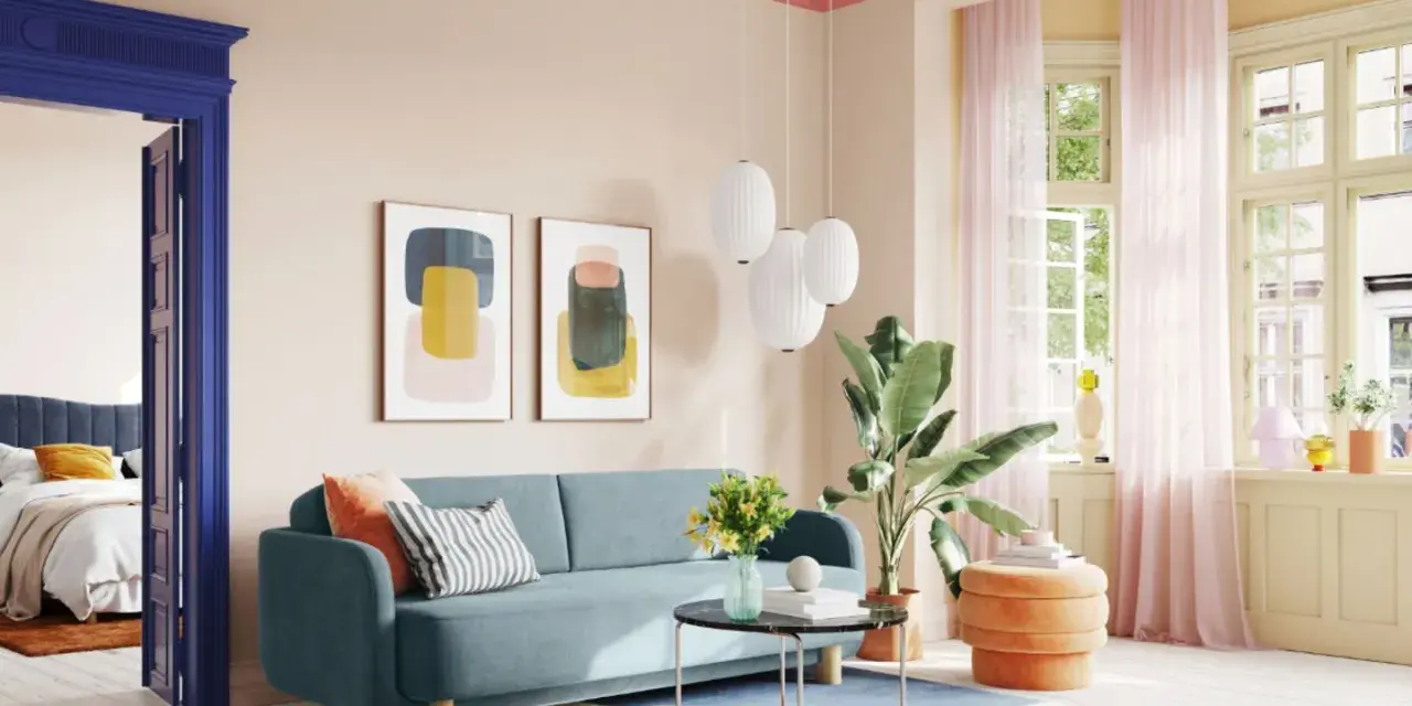 Ein Wohnzimmer mit hellrosa Decke und Wand, blauem Sofa, bunten Bildern und einem Durchgang zu einem Schlafzimmer.