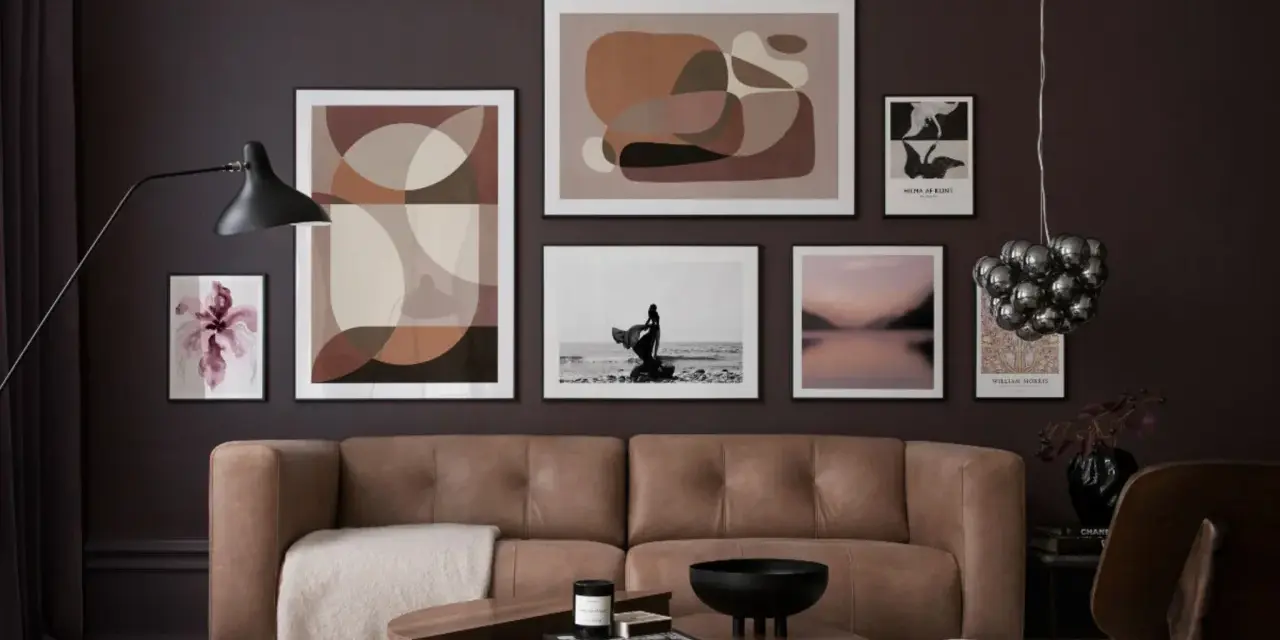 Braune und beige Töne passen wunderbar zu Schwarz. Ein stilvolles Wohnzimmer mit brauner Ledercouch, Kunstwerken und einem Couchtisch.