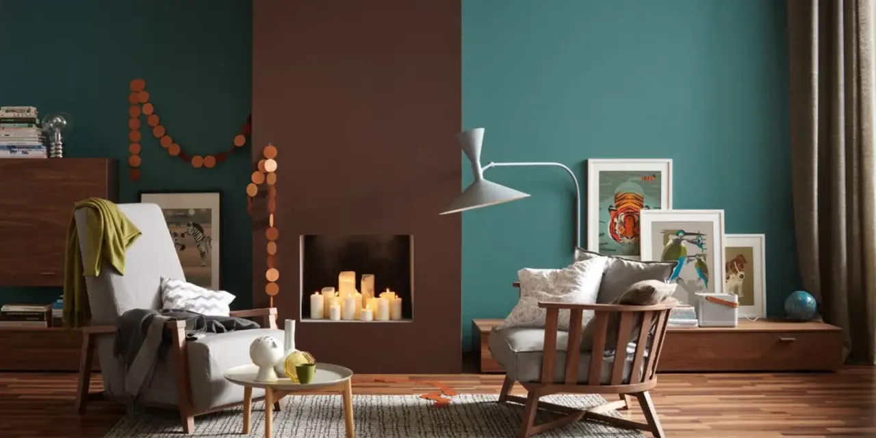 Gemütliches Wohnzimmer: Holz und Farben kombinieren. Zwei Sessel, Kamin mit Kerzen, Bilder und eine Lampe.