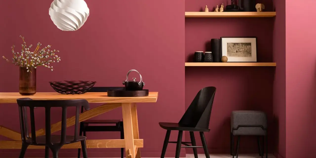 Esszimmer mit Holztisch, schwarzen Stühlen und Wandfarbe Beere kombinieren. Ein moderner Look, der Gemütlichkeit ausstrahlt.