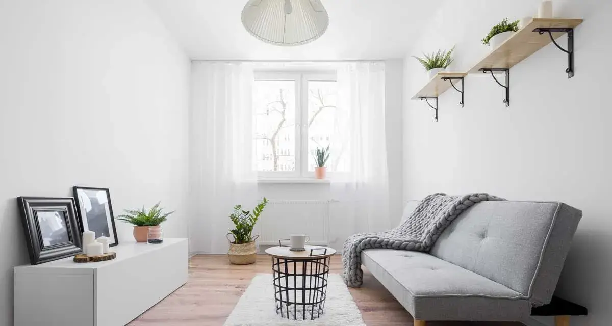 Ein gemütliches Schlauchzimmer einrichten: Helles Sofa, Teppich, Beistelltisch, Pflanzen und Bilder schaffen eine wohnliche Atmosphäre.