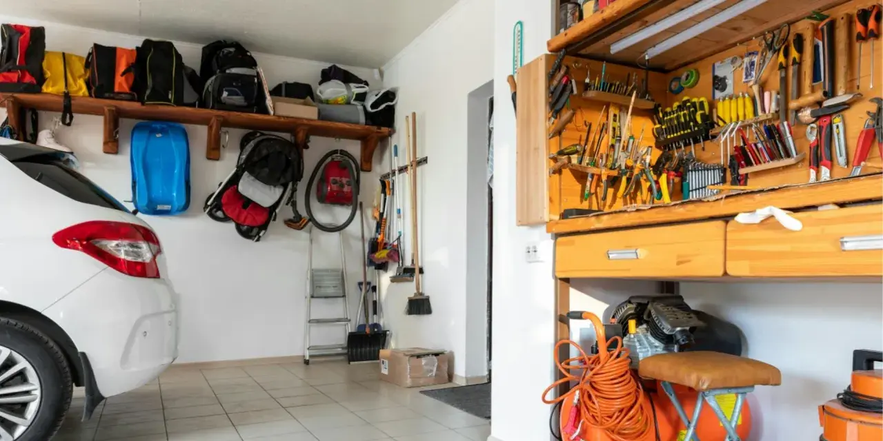 Praktische garage einrichten ideen: Werkzeugwand, Regale mit Taschen und ein Kompressor schaffen Ordnung.