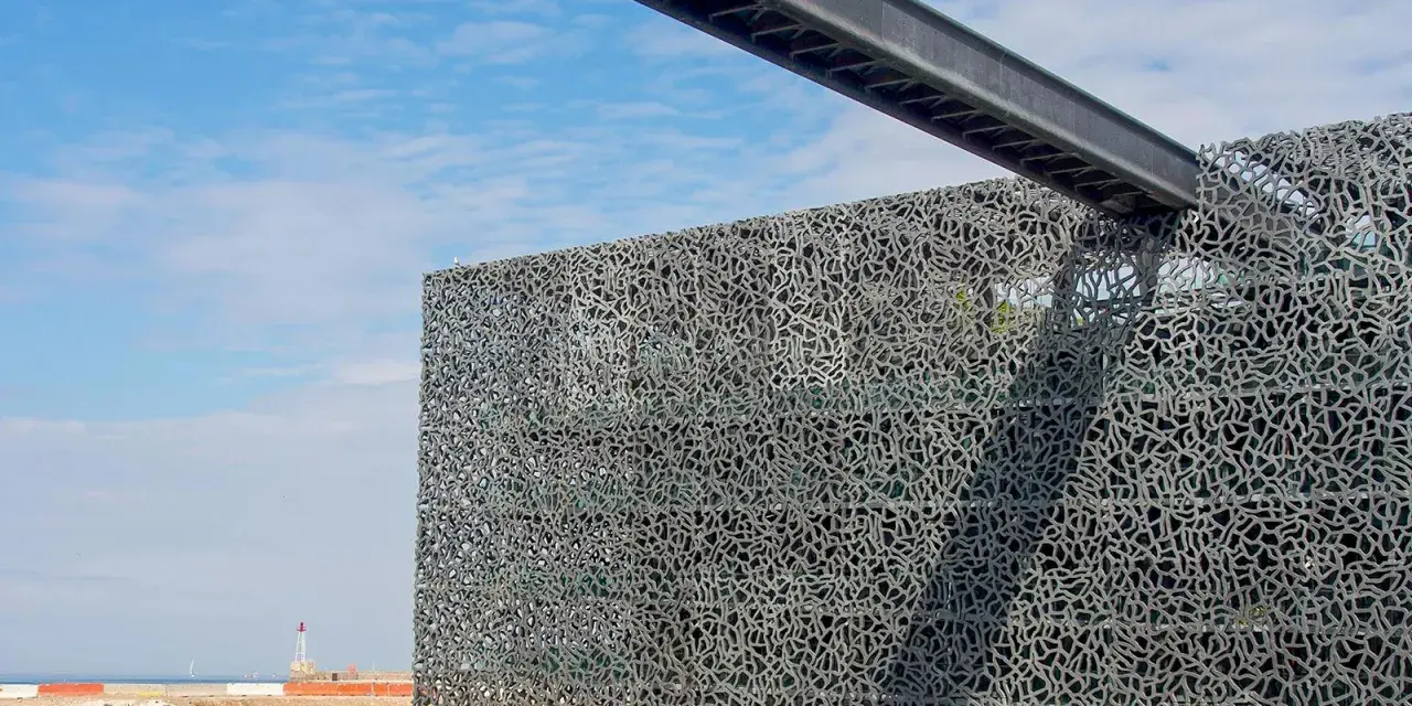 Das MuCEM Marseille mit seiner faszinierenden Gitterfassade, die wie ein Netz wirkt, ragt am Hafen auf.