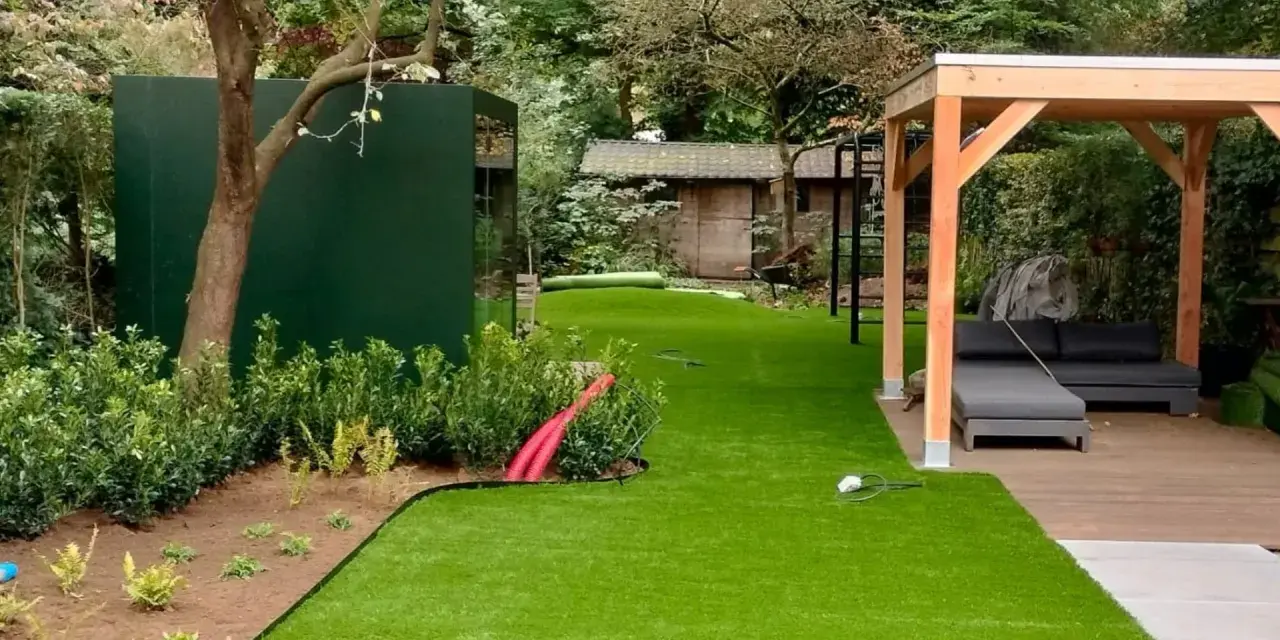Moderne Gartenaufteilung mit Kunstrasen, Holzpavillon, Lounge-Möbeln und grüner Wand. Tolle Ideen für Ihren Garten!