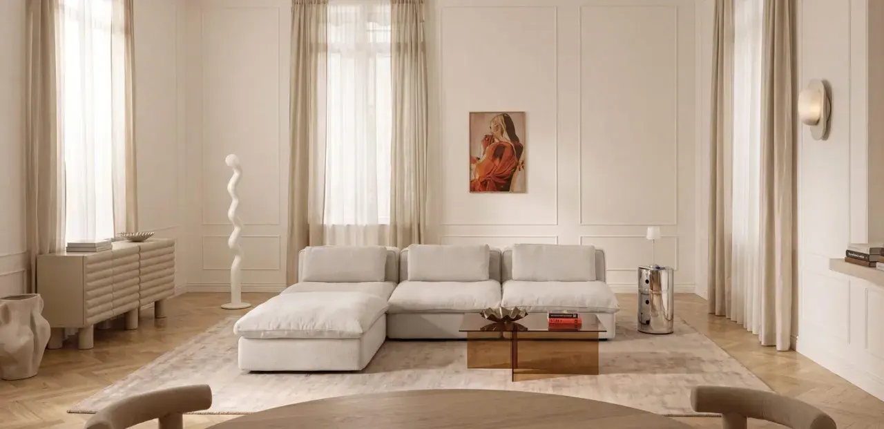 Ein Wohnzimmer in sanften Tönen. Die Farbe Ecru dominiert bei Sofa, Teppich und Vorhängen und schafft eine warme, einladende Atmosphäre.