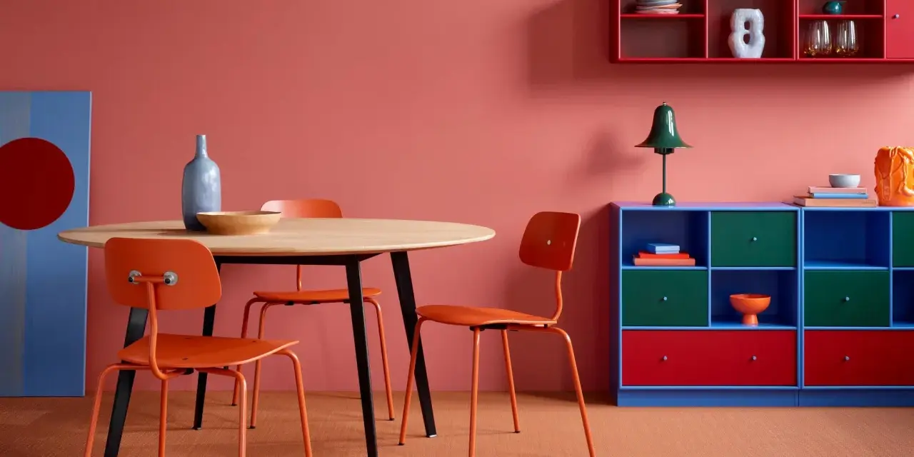Ein Esszimmer mit roten Akzenten: Orange Stühle, ein blauer Schrank und rote Regale zeigen, welche Farben passen zu Rot.
