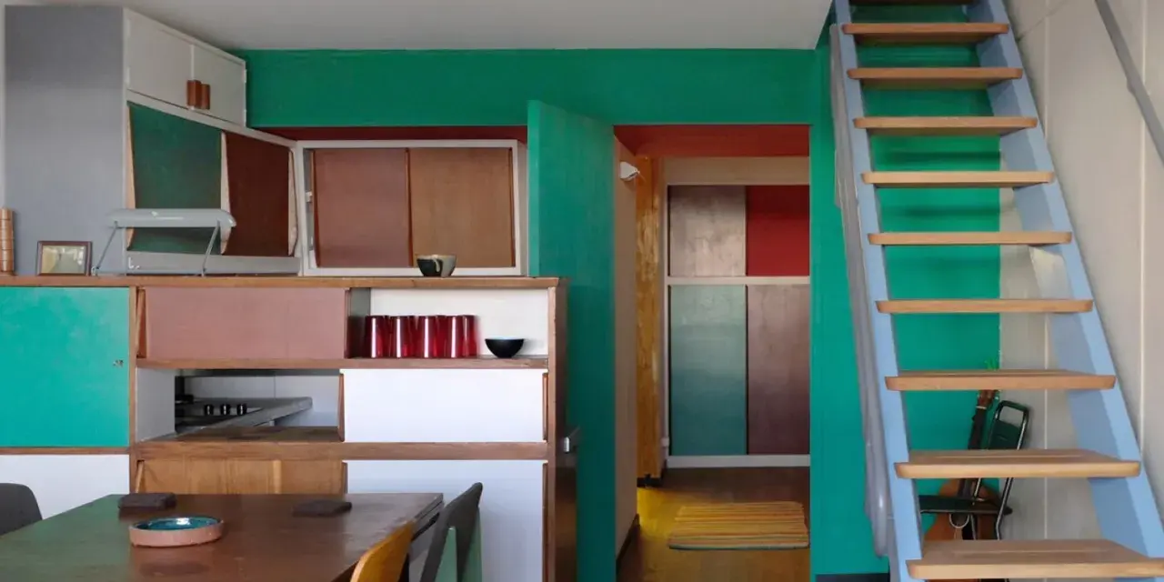 Einblick in eine Wohnung im Stil von Le Corbusier in Berlin: bunte Wände, Holzmöbel und eine Leiter.