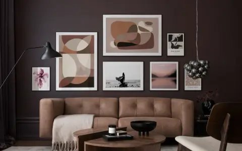 Braune und beige Töne passen wunderbar zu Schwarz. Ein stilvolles Wohnzimmer mit brauner Ledercouch, Kunstwerken und einem Couchtisch.