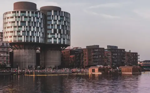 Moderne Architektur und schwimmende Holzhäuser am Wasser in Nordhavn Kopenhagen. Menschen genießen die Abendsonne.