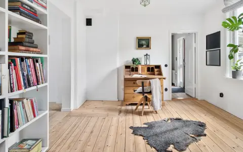 Ein heller Raum mit Bücherregalen, einem antiken Schreibtisch und Pflanzen. Perfekt für ausmisten tipps, um Ordnung zu schaffen.