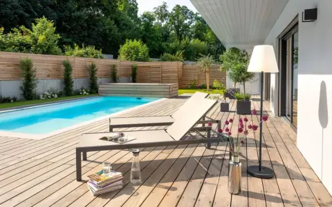 Traumhafte gartengestaltung mit pool und terrasse. Zwei Liegen laden zum Entspannen ein, während der Pool erfrischt.