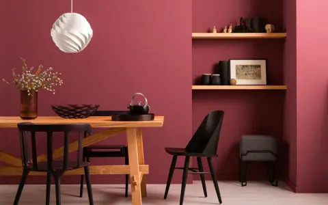 Esszimmer mit Holztisch, schwarzen Stühlen und Wandfarbe Beere kombinieren. Ein moderner Look, der Gemütlichkeit ausstrahlt.