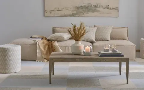 Gemütliches, **ästhetisches Zimmer** mit beigem Sofa, Holztisch, Kerzen und Deko.