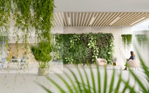Ein Büro mit biophilem Design: Eine üppige grüne Wand und hängende Pflanzen schaffen eine beruhigende Atmosphäre. Menschen arbeiten und entspannen sich inmitten der Natur.