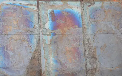 Verwittertes Metall mit schillernden Farben, die die Bedeutung von Patina zeigen. Rostige und blaue Muster erzählen eine Geschichte der Zeit.