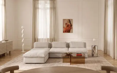 Ein Wohnzimmer in sanften Tönen. Die Farbe Ecru dominiert bei Sofa, Teppich und Vorhängen und schafft eine warme, einladende Atmosphäre.