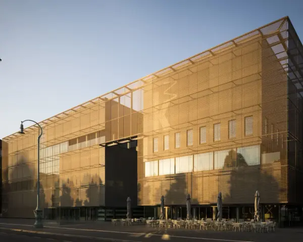 Moderne Architektur der Kunsthalle Mannheim im goldenen Abendlicht. Vor dem Gebäude laden Tische und Stühle zum Verweilen ein.