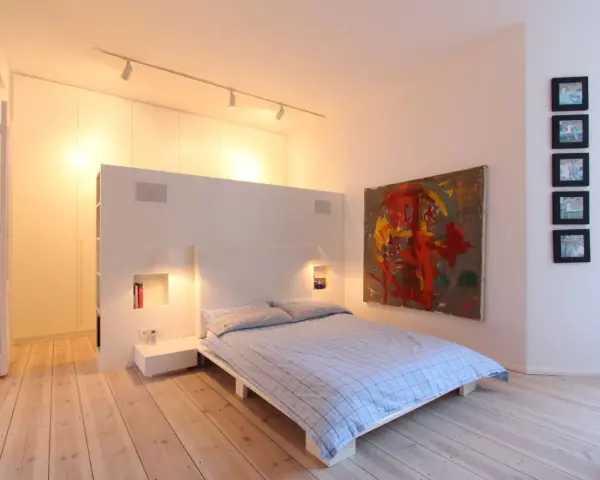 Modernes Schlafzimmer mit Bett, Kunstwerk und Einbauschränken. Tolle Renovierungsideen für minimalistische Räume.