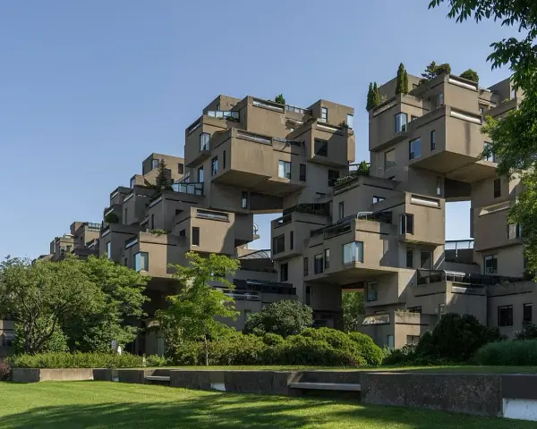 Ein beeindruckendes Beispiel brutalistischer Architektur: Betonblöcke stapeln sich zu einer futuristischen Wohnanlage, umgeben von Grün.