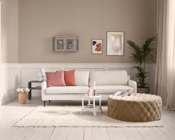 Gemütliches Wohnzimmer mit beigem Teppich und Hocker. Hier siehst du, wie man beige mit anderen Farben mischt.