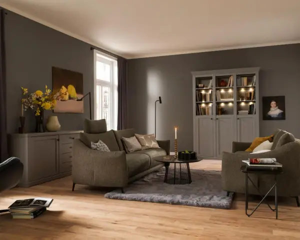 Gemütliches Wohnzimmer mit einem weichen, grauen Teppich unter dem Sofa und einem Sessel.