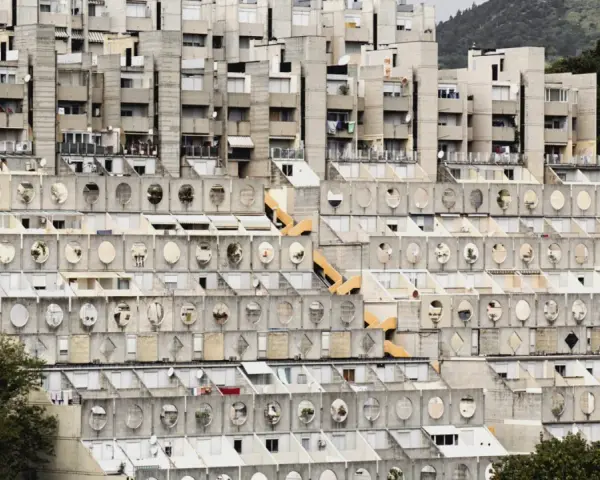 Massive Wohnanlage im Stil der brutalismus architektur, mit terrassierten Ebenen und vielen runden Fenstern.