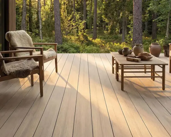 Holzdeck mit bequemen Sesseln und Tisch, umgeben von Wald. Ein **garten skandinavisch gestalten** – minimalistisch und naturverbunden.