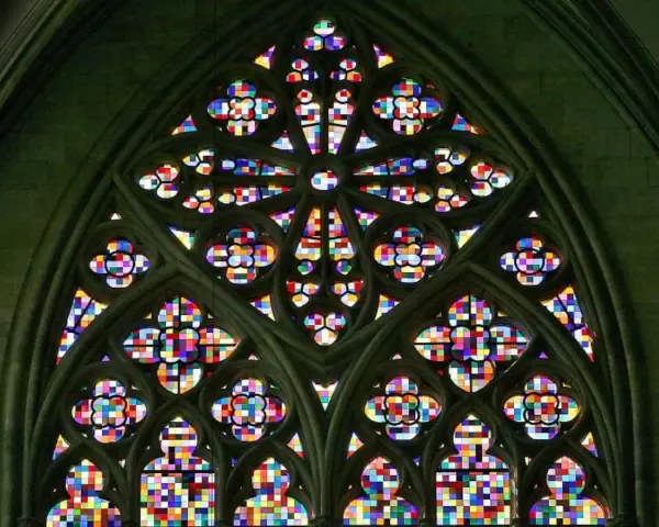 Ein farbenprächtiges Rosettenfenster im gotischen Baustil, das durch seine filigrane Steinarchitektur und das leuchtende Glas beeindruckt.