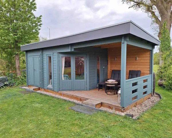 Ein blaugrünes Gartenhaus mit Veranda und Sitzgelegenheiten. Tolle Gartenhaus Farben Ideen für Ihr grünes Paradies.